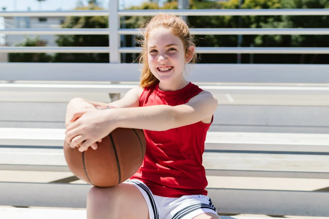 girl with basketball wearing jersey